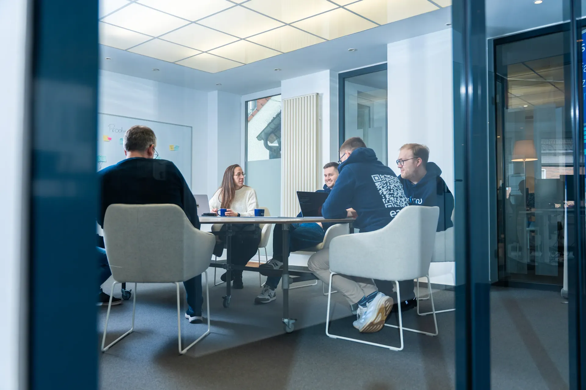 Team von easimo sitzt in einer Besprechung im modernen Büro zur webbasierten Immobilienverwaltungssoftware für Hausverwaltungen.